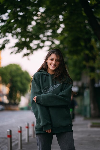 Retrato de linda chica con cabello largo en la ciudad en la calle