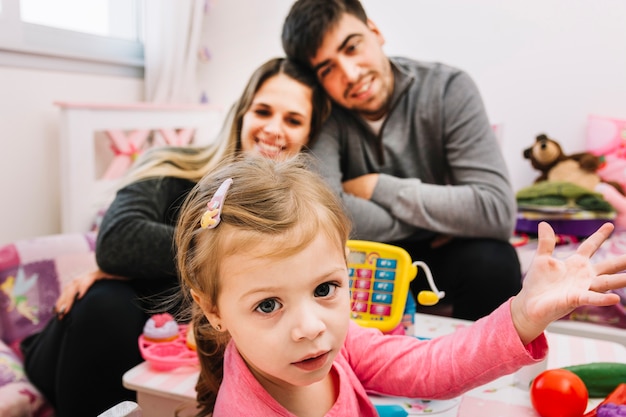 Retrato de una linda chica delante de sus felices padres