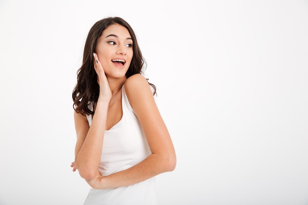 Retrato de una linda chica vestida con una camiseta sin mangas mirando a otro lado