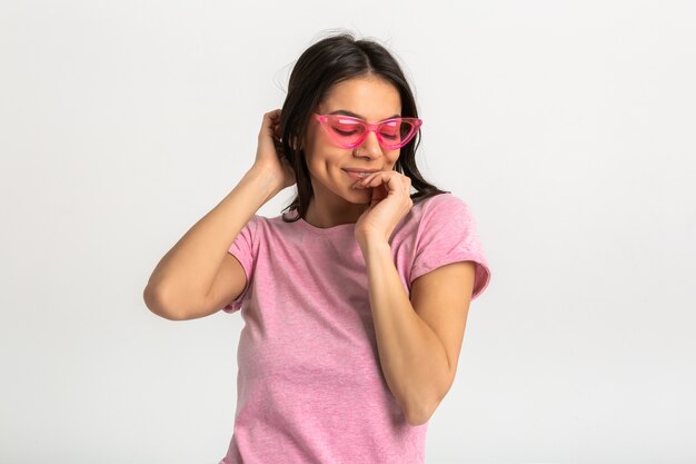 Retrato de linda mujer emocional muy sonriente en camisa rosa y elegantes gafas de sol, posando positivo aislado