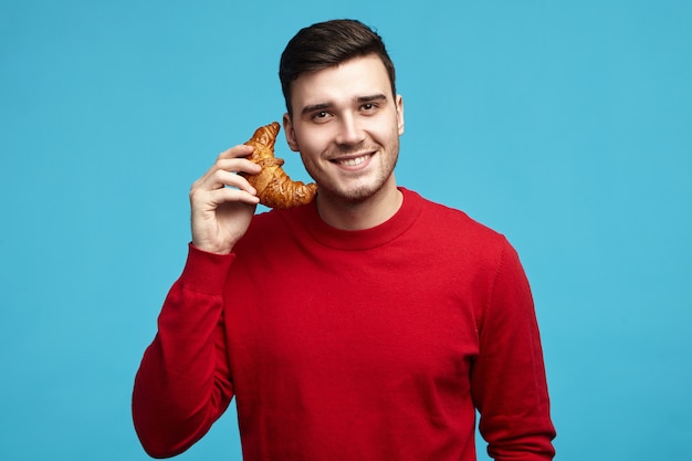 Retrato de lindo encantador joven varón sin afeitar de pelo oscuro mirando a la cámara