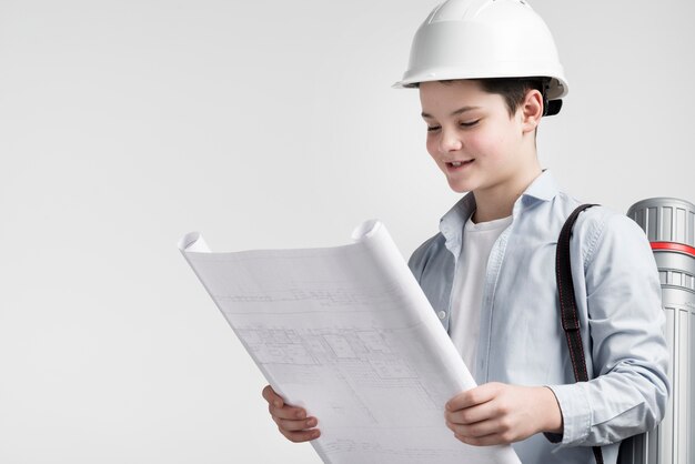 Retrato de lindo joven ingeniero leyendo el plan de construcción