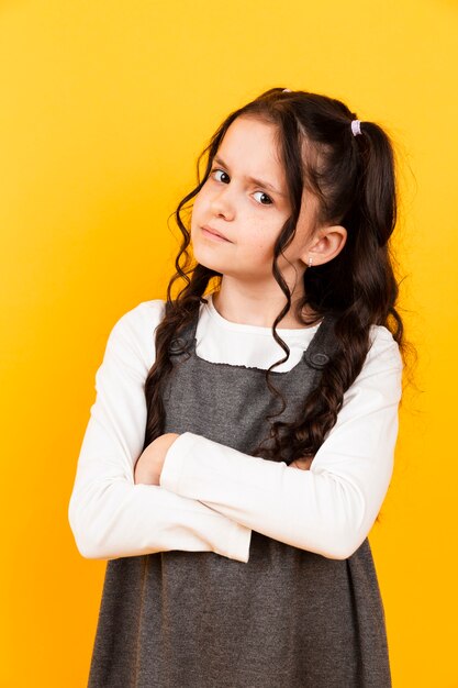 Retrato lindo de la niña que presenta en fondo amarillo