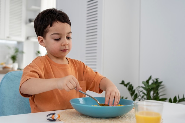 Foto gratuita retrato de lindo niño desayunando