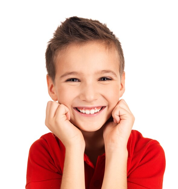 Retrato de un lindo niño feliz con bonita sonrisa. Foto en pared blanca