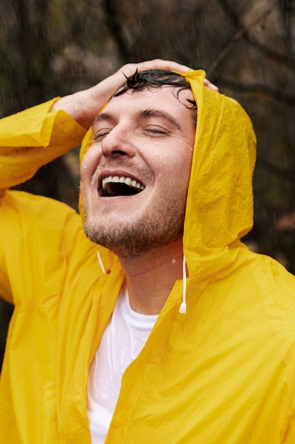 Retrato de lluvia de joven en capa de lluvia