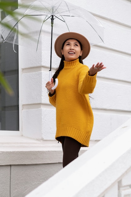 Foto gratuita retrato de lluvia de mujer joven y hermosa con paraguas