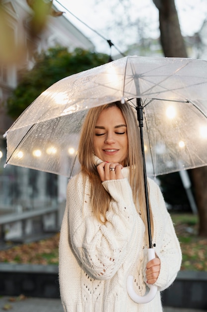 Retrato de lluvia de mujer joven y hermosa con paraguas