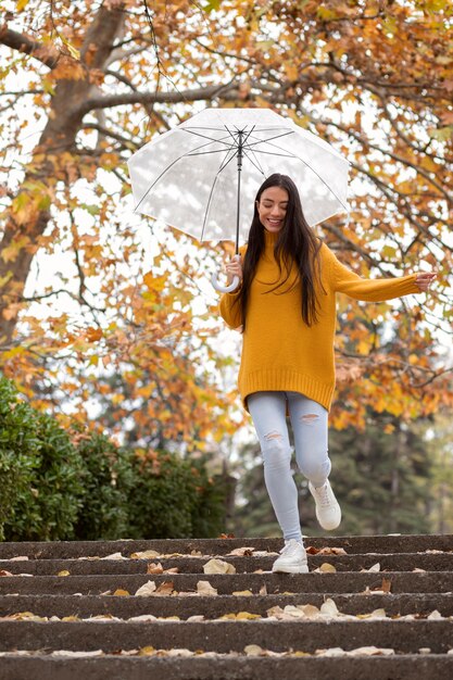 Retrato de lluvia de mujer joven y hermosa con paraguas
