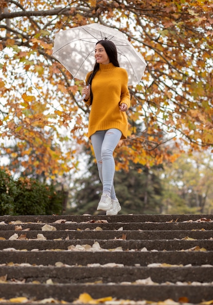 Retrato de lluvia de mujer joven y hermosa con paraguas