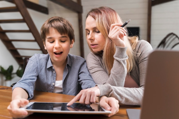 Foto gratuita retrato de madre ayudando a hijo con la tarea