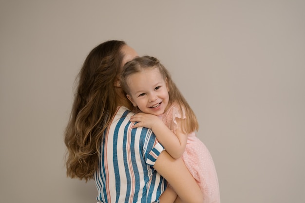 Retrato de madre e hija sobre fondo beige