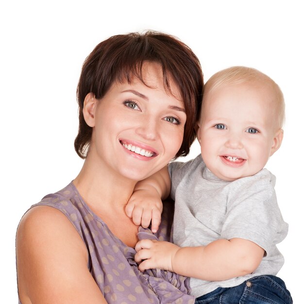 Retrato de la madre feliz con bebé sonriente sobre fondo blanco.
