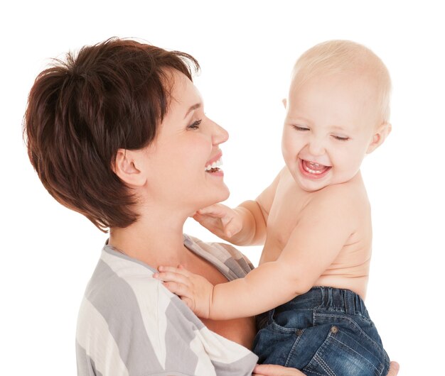 Retrato de la madre feliz con bebé sonriente sobre fondo blanco.