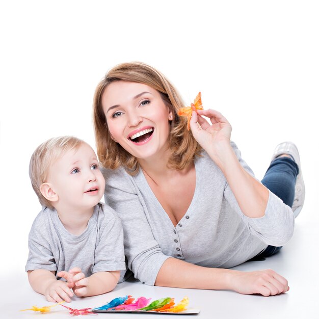 Retrato de madre feliz jugando con niño acostado - aislado en blanco