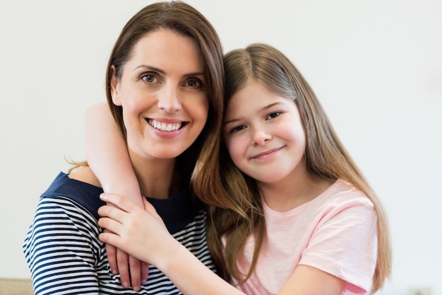 Retrato de la madre y la hija que se abrazan en la vida r