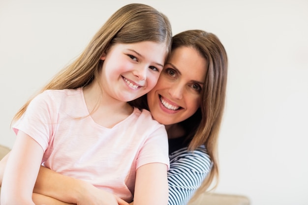 Retrato de la madre y la hija que se abrazan en la vida r