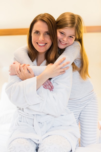 Retrato de la madre y la hija que se abrazan