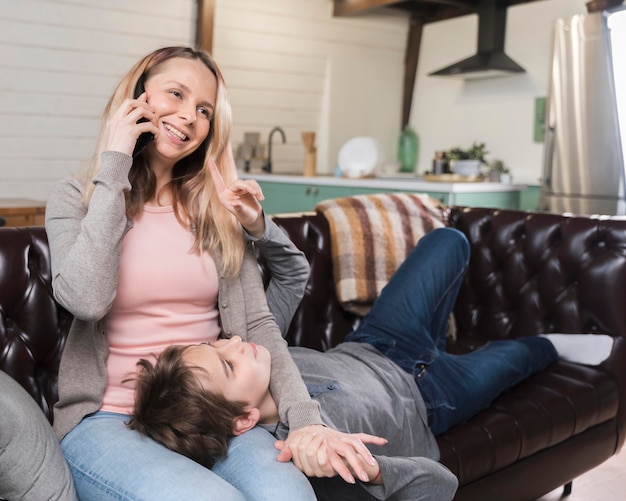 Foto gratuita retrato de madre relajante con hijo en el sofá