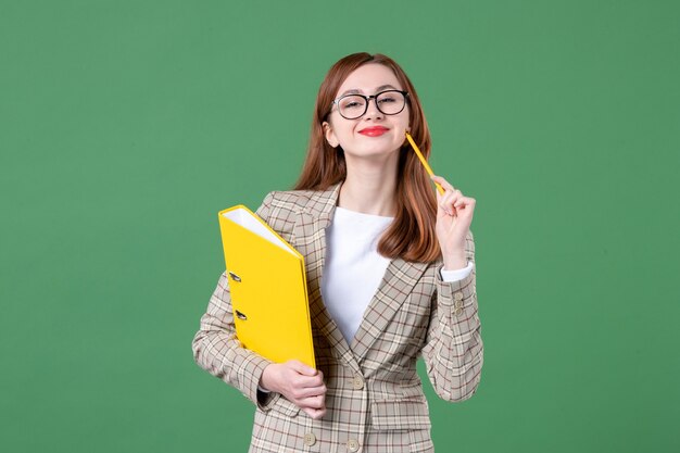 Retrato de maestra con archivos amarillos sobre verde