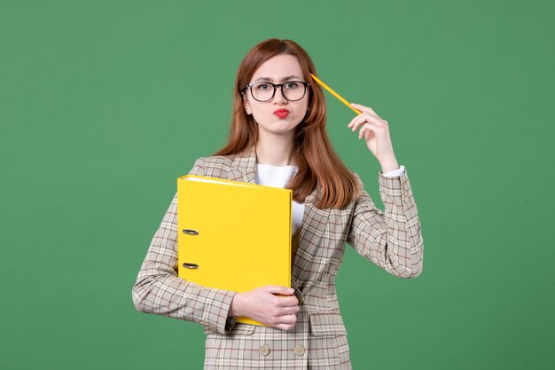 Retrato de maestra con archivos amarillos sobre verde