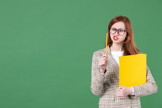 Retrato de maestra con documento amarillo sobre verde