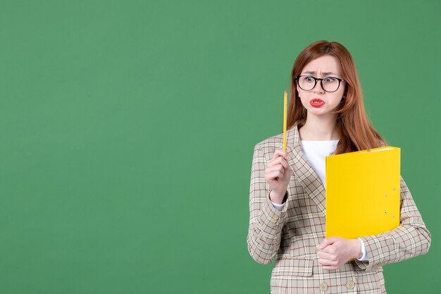 Retrato de maestra con documento amarillo sobre verde