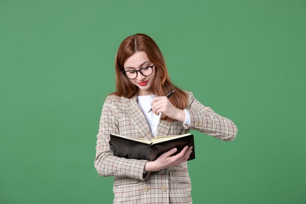 Retrato de maestra escribiendo notas en verde