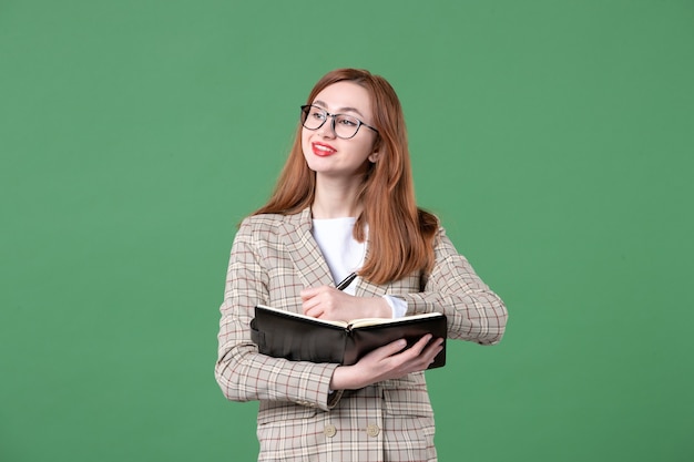 Retrato de maestra escribiendo notas en verde