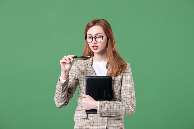 Retrato de maestra en traje con bloc de notas en verde