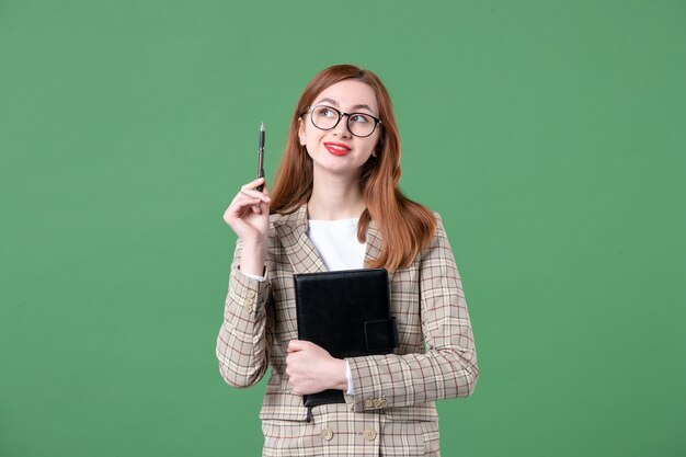 Retrato de maestra en traje con bloc de notas en verde