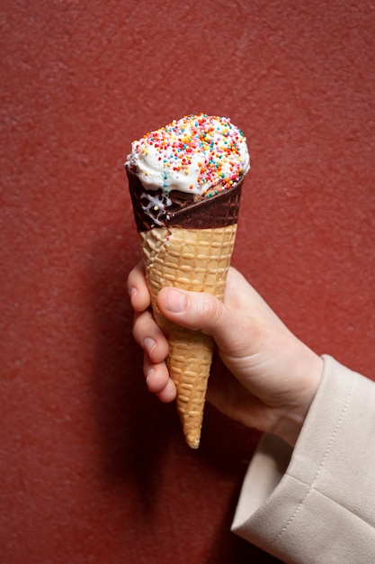 Foto gratuita retrato de mano sujetando cono de helado