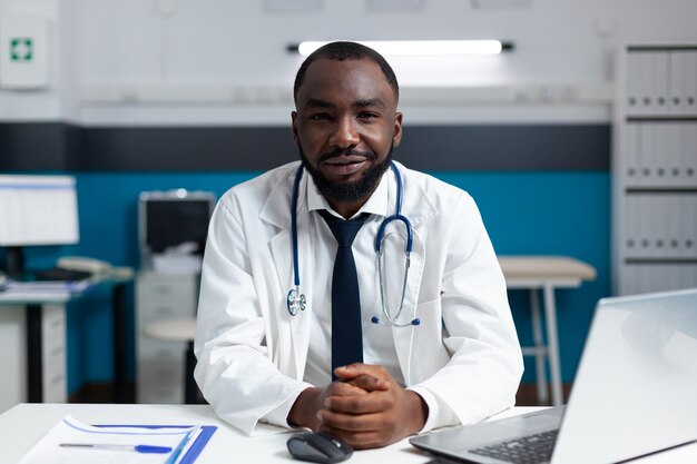 Retrato del médico afroamericano que trabaja en la oficina del hospital