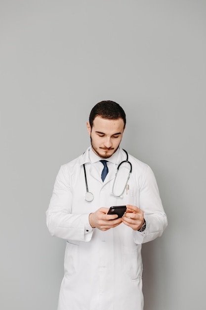 Retrato de un médico amistoso aislado en gris