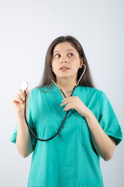 Retrato de un médico joven con estetoscopio en uniforme.