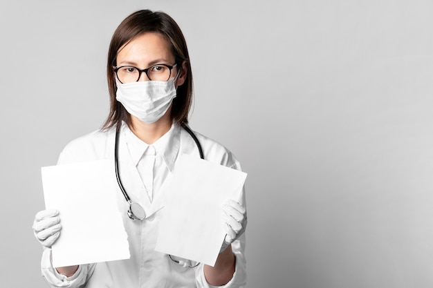 Retrato de médico con máscara quirúrgica con papeles