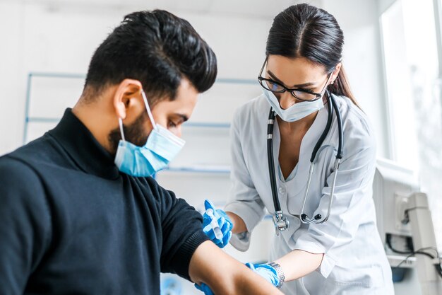 Retrato de un médico de una mujer que vacuna a un paciente, vacunación contra coronavirus, protección contra covid, protección contra infecciones