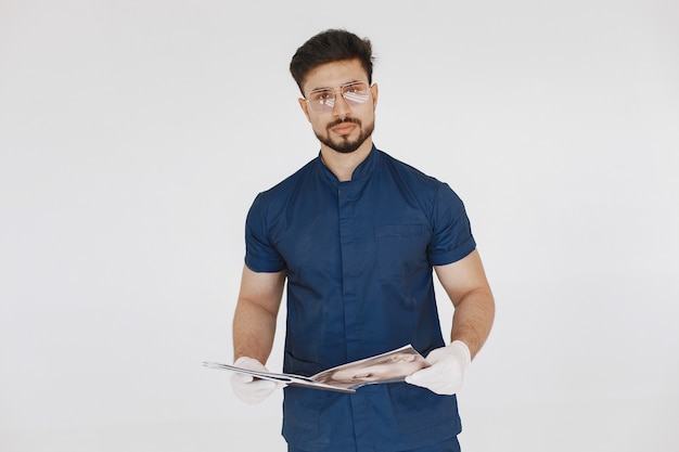 Un retrato de un médico posando sobre fondo blanco.