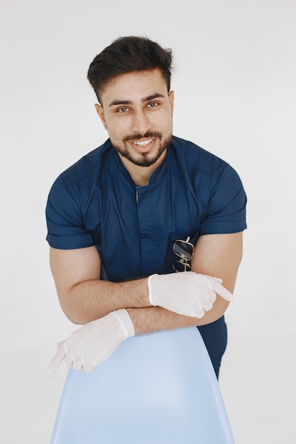 Un retrato de un médico posando sobre fondo blanco.