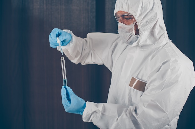 Foto gratuita retrato de un médico tomando muestras de medicamentos con máscara, guantes y traje protector