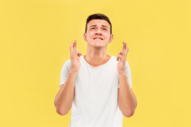 Retrato de medio cuerpo del joven caucásico en estudio amarillo