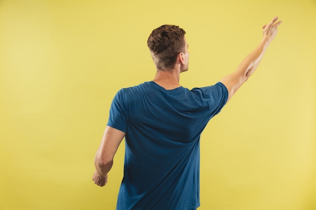 Foto gratuita retrato de medio cuerpo del joven caucásico en estudio amarillo