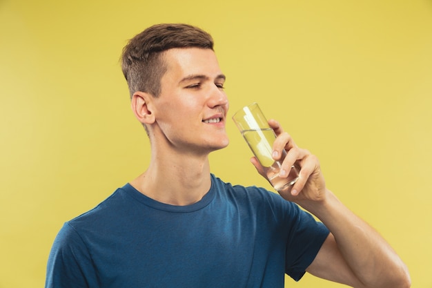 Foto gratuita retrato de medio cuerpo del joven caucásico en estudio amarillo