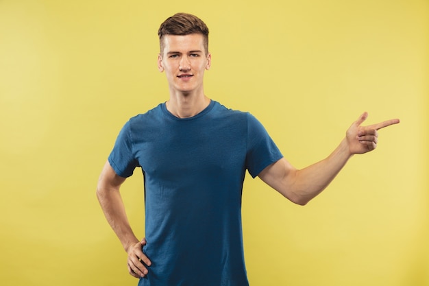 Retrato de medio cuerpo del joven caucásico Hermoso modelo masculino en camisa azul. Concepto de emociones humanas, expresión facial.