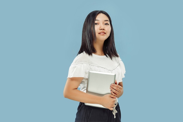 Retrato de medio cuerpo de la joven coreana en estudio azul