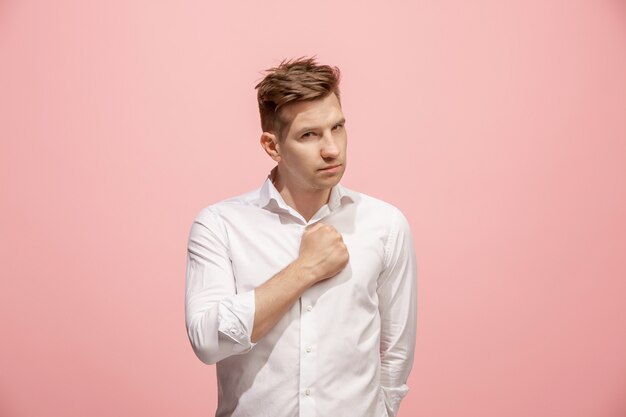 Retrato de medio cuerpo masculino hermoso aislado en el fondo de color rosa de estudio. El joven sorprendido emocional