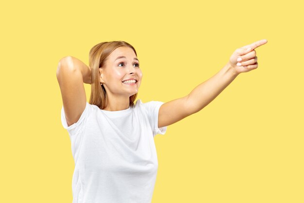 Retrato de medio cuerpo de la mujer joven caucásica sobre fondo amarillo de estudio. Hermosa modelo de mujer en camisa blanca