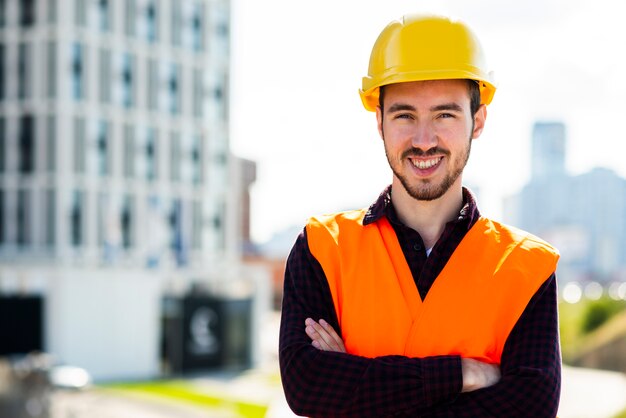 Retrato medio del trabajador de construcción que mira la cámara