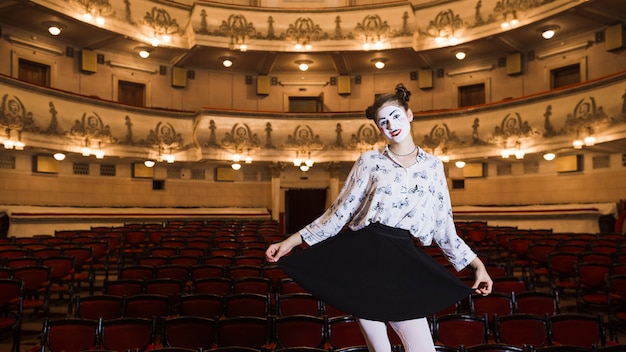 Retrato del mime femenino que se coloca en un auditorio que presenta