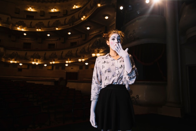 Retrato de mimo mujer sorprendida de pie en el auditorio